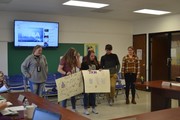 students with posters in front of board