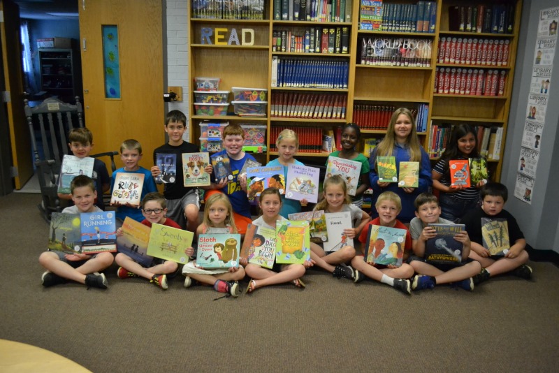 students with donated books from book buzz